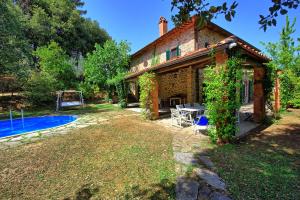 een huis met een zwembad ervoor bij Villa Ulivacci by PosarelliVillas in Cavriglia