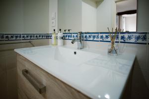 a bathroom with a white sink and blue and white tiles at Casa Mindela Farmhouse in Vila do Conde +116 photos