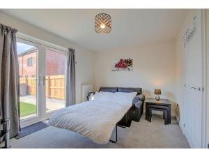 a bedroom with a bed and a window at Newly built, splendid house for 5 in Manchester! in Manchester