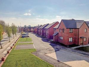 a row of red brick houses on a street at Newly built, splendid house for 5 in Manchester! in Manchester