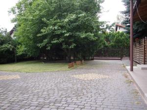a brick driveway with trees and a fence at Apartamenty Dobranoc - Wawer in Warsaw