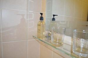 uma casa de banho com duas garrafas e copos numa prateleira em Central Hotel em Sutton in Ashfield mais 21 fotografias