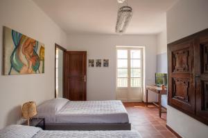 a bedroom with two beds and a desk and a window at AMERICA NEI BOSCHI B&B in Bra
