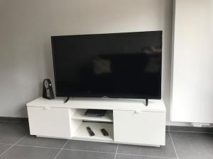 a flat screen tv sitting on a white entertainment center at Residentie Sorrento in Middelkerke