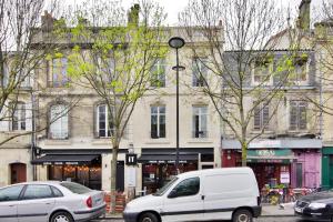 uma carrinha branca estacionada em frente a um edifício em Les Halles et Hauteurs by Cocoonr em Bordeaux