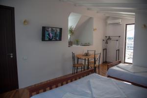巴统Cozy Guest House in Old Batumi的一间卧室配有桌子、床和桌椅