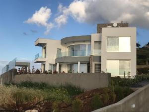 una casa blanca con gente parada fuera de ella en Elite Sea View Villa, en Pomos
