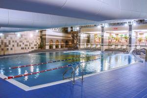 a large indoor swimming pool in a building at Cosmos Hotel in Moscow