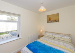 a bedroom with a bed and a window at Garra Cottage in Drogheda