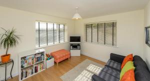 a living room with a black couch and a tv at Garra Cottage in Drogheda