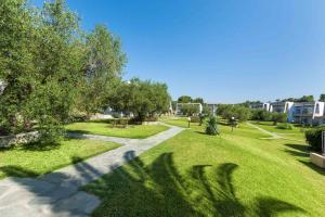 a park with trees and grass and a sidewalk at Iris Hotel in Siviri