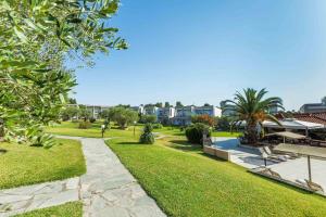 a park with a pathway and grass and buildings at Iris Hotel in Siviri