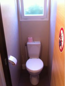 a small bathroom with a toilet with a window at GRAND MOBILEHOME PROCHE COMMODITE FO10 in Fréjus