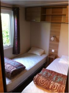 um pequeno quarto com 2 camas e uma janela em GRAND MOBILEHOME PROCHE COMMODITE FO10 em Fréjus