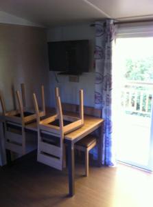 a dining room with a table and chairs and a television at GRAND MOBILEHOME PROCHE COMMODITE FO10 in Fréjus