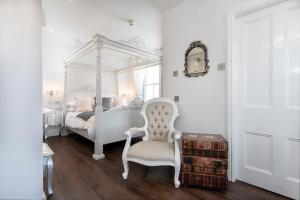 ein Schlafzimmer mit einem Bett, einem Stuhl und einem Spiegel in der Unterkunft Gwynfryn in Conwy