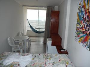 um quarto com uma cama e uma janela com uma rede de descanso em Suite Vista Mar em Salvador