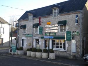 ein Steingebäude mit Schildern davor in der Unterkunft HOTEL DU CYGNE DE LA CROIX BLANCHE in Lailly-en-Val