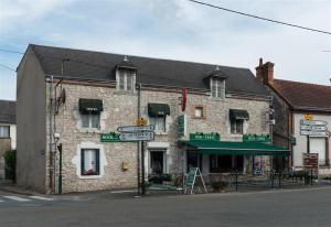 - un vieux bâtiment en pierre au coin d'une rue dans l'établissement HOTEL DU CYGNE DE LA CROIX BLANCHE, à Lailly-en-Val
