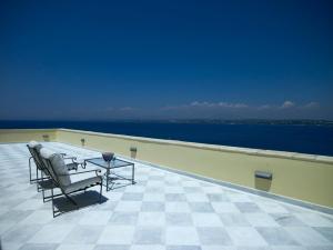 a patio with chairs and a table on a roof at Poseidonion Grand Hotel in Spetses