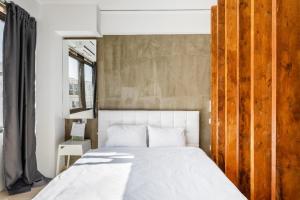 1 dormitorio con cama blanca y ventana en Tsimiski double suites #8, en Tesalónica