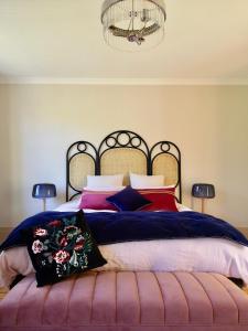 a bedroom with a large bed with colorful pillows at Le Clos des Fées in Asnières-sur-Oise