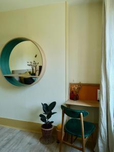 a room with a chair and a mirror on the wall at Le Clos des Fées in Asnières-sur-Oise