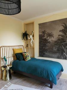 a bedroom with a bed and a painting on the wall at Le Clos des Fées in Asnières-sur-Oise