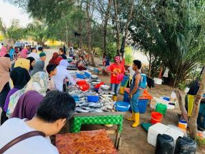 un grupo de personas sentadas alrededor de una mesa con comida en The Collector at Bayu Puteri Mid Valley 2 mins drive en Johor Bahru