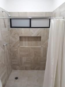 um chuveiro com uma cortina de chuveiro branca na casa de banho em Estudio en Cancún centro em Cancún