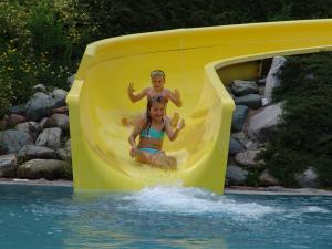 Dos niños montados en un tobogán acuático en un parque acuático en Das kleine Berghotel, en Liesing