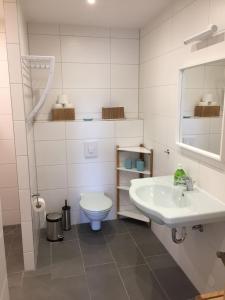 een witte badkamer met een wastafel en een toilet bij Ferienhaus LOOP IN in Ribnitz-Damgarten