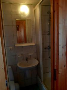 La petite salle de bains est pourvue d'un lavabo et d'un miroir. dans l'établissement Pokoje u Heleny, à Leśnica