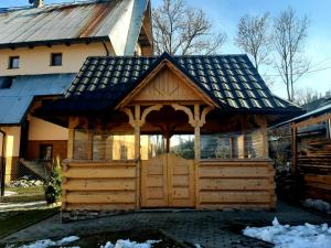 a wooden gazebo in front of a house at Pokoje u Heleny in Leśnica