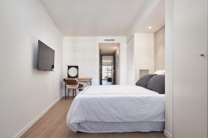 Habitación blanca con cama y escritorio en 3P BETWEEN CROISETTE BEACHES AND ANTIBES STREET, en Cannes