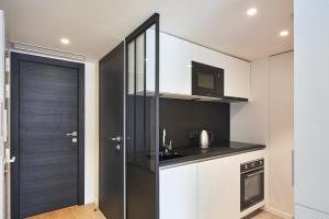 a kitchen with white cabinets and a black door at 3P BETWEEN CROISETTE BEACHES AND ANTIBES STREET in Cannes