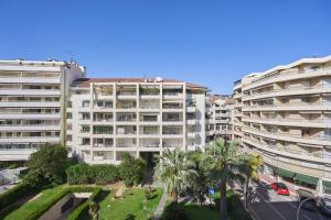 un edificio de apartamentos con palmeras frente a una calle en 3P BETWEEN CROISETTE BEACHES AND ANTIBES STREET, en Cannes