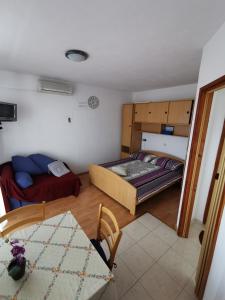 Apartments Sevo في تروغير: غرفة نوم بسرير واريكة وطاولة