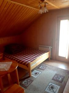 a bed in a room with a wooden ceiling at Pokoje u Heleny in Leśnica
