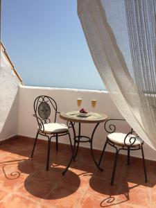 dos sillas y una mesa con dos copas de vino en LUXURY DUPLEX WITH VIEWS., en Marbella