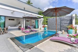 uma piscina com cadeiras roxas e um guarda-sol em Villa Moumel, Lamai Koh Samui em Lamai