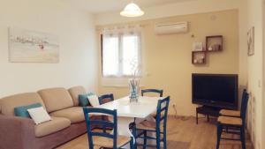 un soggiorno con un divano e un tavolo con sedie di Apartment Conchiglie a Cala Gonone