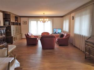 a living room with chairs and a couch and a television at Zwischen Mozart und König Ludwig in Teisendorf