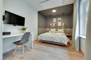 ソポトにあるMonte Cassino Chill - Comfy Apartmentsのベッドルーム1室(ベッド1台、壁にテレビ付)