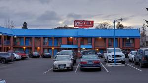 a motel with cars parked in a parking lot at Motel West in Bend