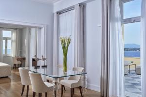 a dining room with a glass table and chairs at Poseidonion Grand Hotel in Spetses