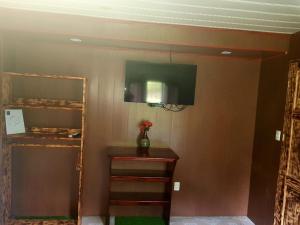 ein Wohnzimmer mit einem TV an der Wand in der Unterkunft Hotel Maguey in Chilamate