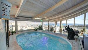 een groot zwembad in een grote kamer met ramen bij Olimpos Eilat in Eilat
