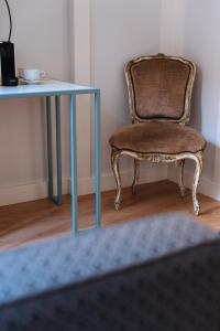 uma cadeira ao lado de uma mesa com uma secretária azul em Hommyhome Regina - Metropol em Sevilha