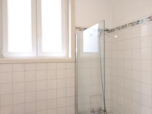 y baño con ducha y puerta de cristal. en Carolina M Apartment in front of Metro, en Oporto